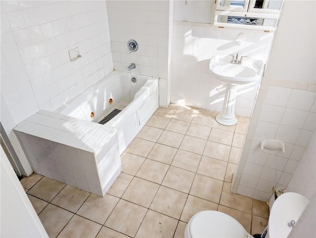 bathroom featuring toilet, tiled shower / bath combo, tile patterned flooring, and tile walls