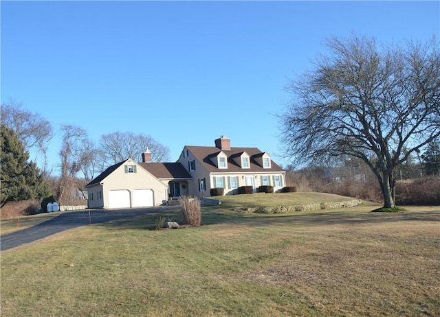 cape cod house featuring a garage and a front lawn