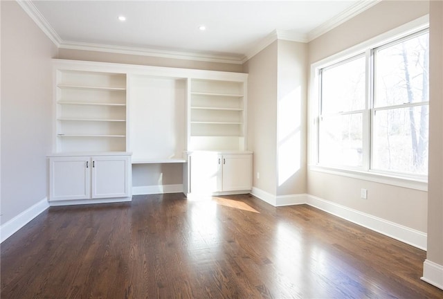 unfurnished living room with built in desk, a wealth of natural light, and ornamental molding