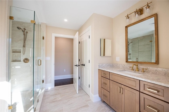 bathroom with a shower with shower door and vanity