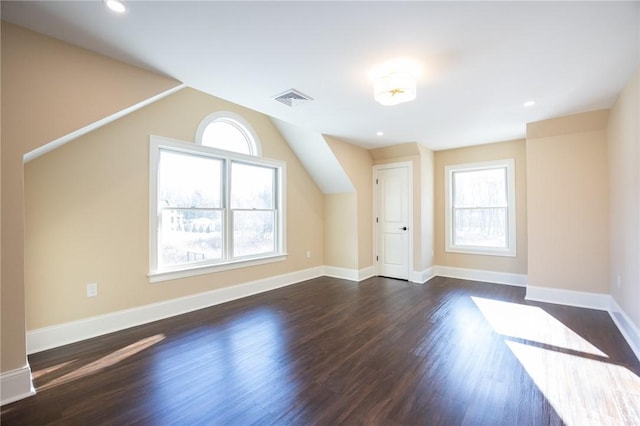 bonus room featuring dark wood-type flooring and plenty of natural light