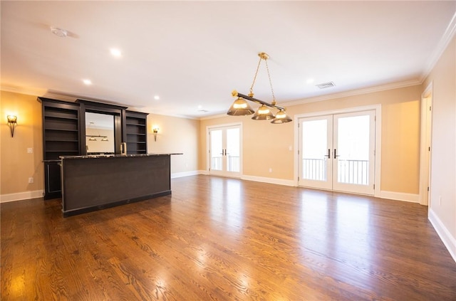 unfurnished living room with a wealth of natural light, crown molding, and french doors