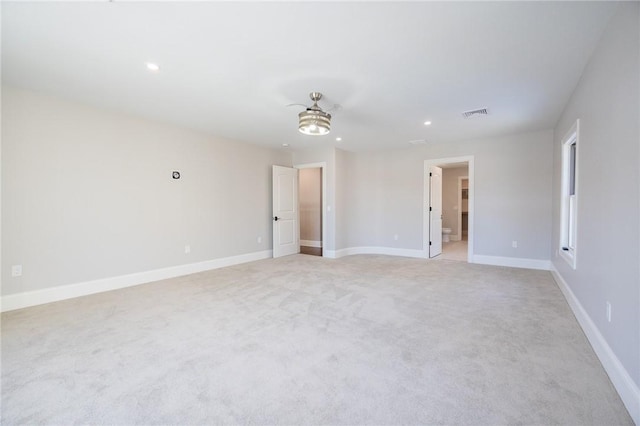 empty room featuring ceiling fan and light carpet