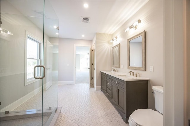 bathroom featuring a shower with shower door, toilet, and vanity