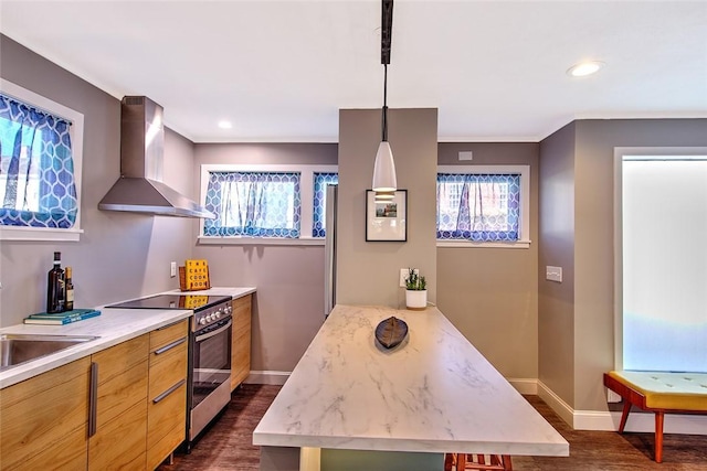 kitchen with dark wood-type flooring, wall chimney range hood, pendant lighting, and stainless steel range with electric stovetop