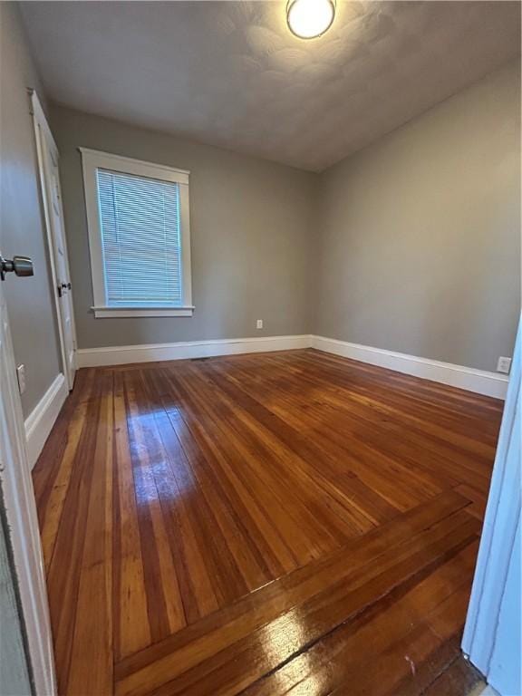 empty room with dark hardwood / wood-style flooring