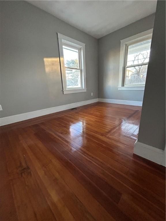 unfurnished room with dark hardwood / wood-style flooring