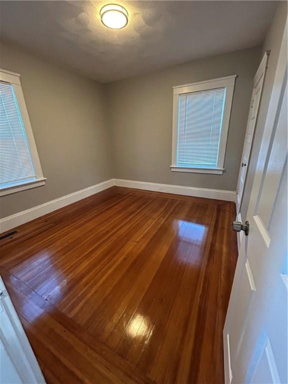 unfurnished room with hardwood / wood-style flooring