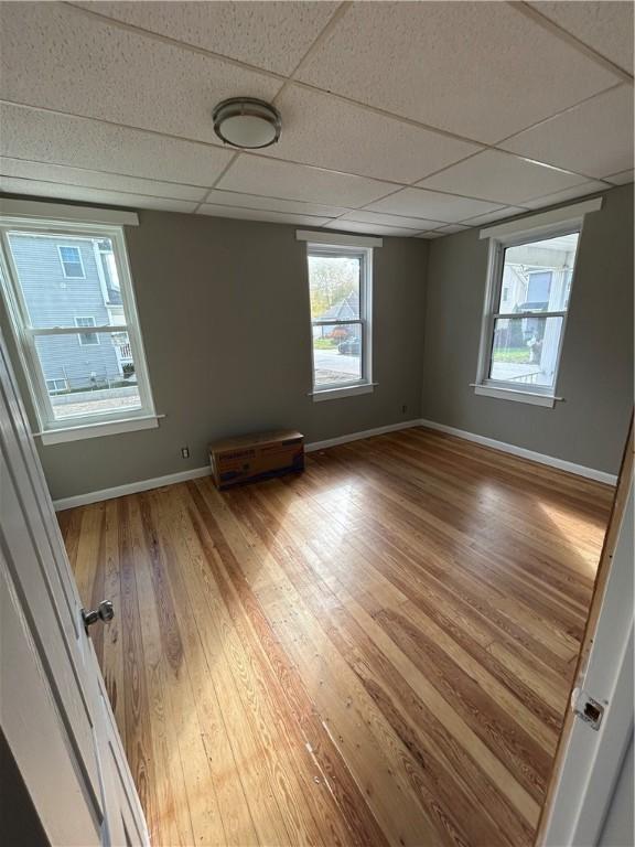 spare room featuring hardwood / wood-style floors and a drop ceiling