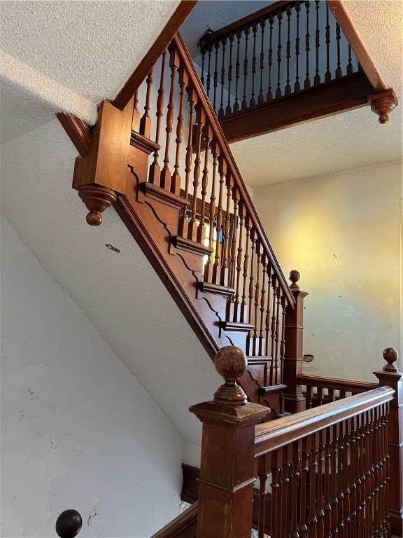 stairway with a textured ceiling