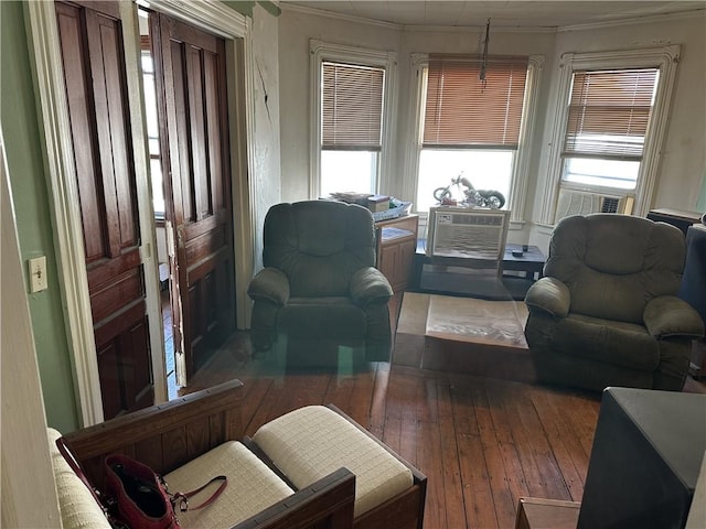 living room with cooling unit, hardwood / wood-style flooring, a wealth of natural light, and ornamental molding