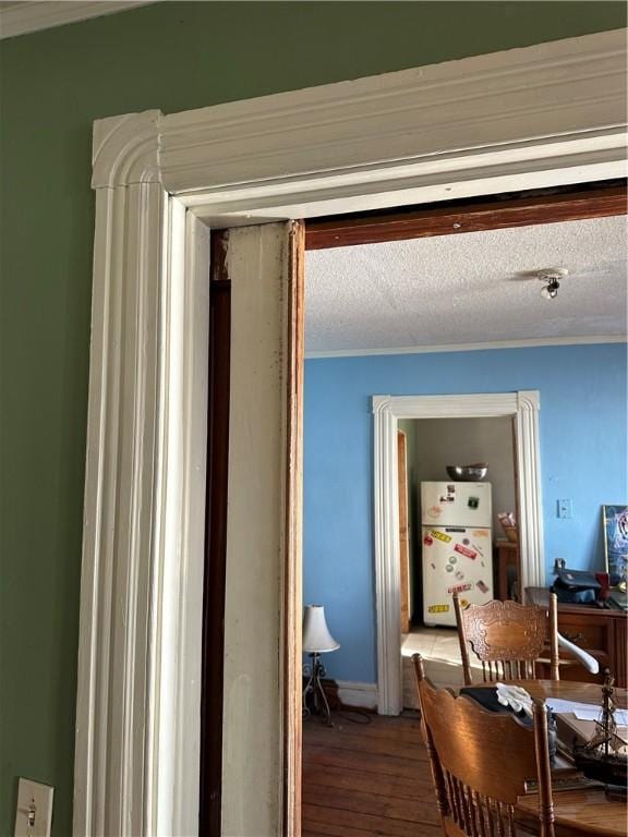 hall featuring wood-type flooring and a textured ceiling