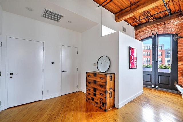 entryway featuring french doors, light hardwood / wood-style flooring, beam ceiling, and wood ceiling