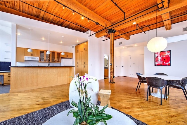 interior space with washer / dryer, wood ceiling, light hardwood / wood-style floors, and beam ceiling