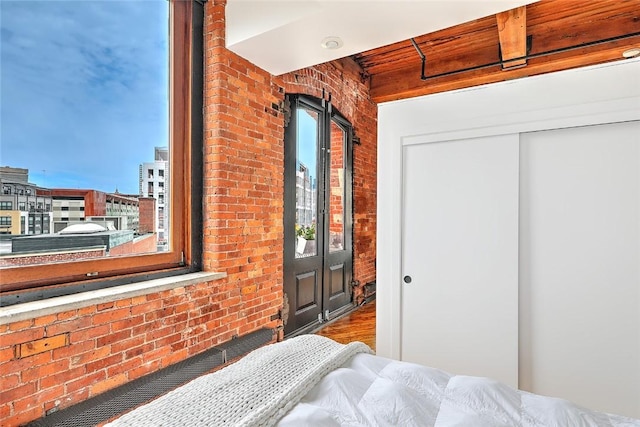 bedroom featuring brick wall and a closet