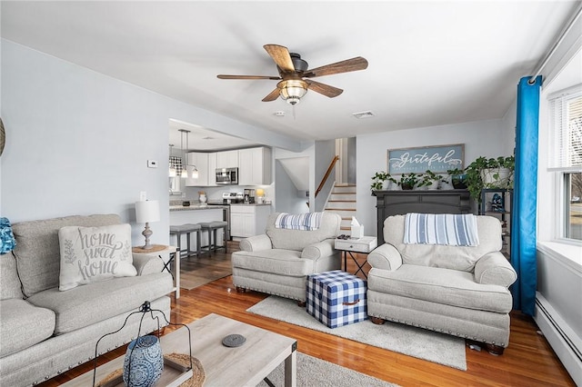 living room featuring ceiling fan, a baseboard radiator, and hardwood / wood-style floors