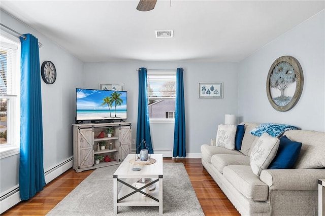 living room featuring ceiling fan, hardwood / wood-style flooring, and a baseboard radiator