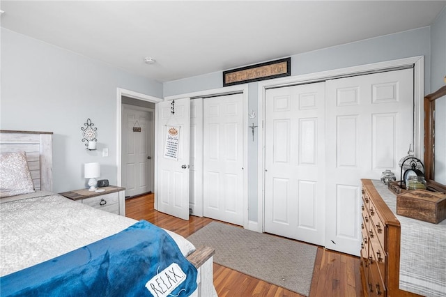 bedroom featuring hardwood / wood-style flooring and multiple closets