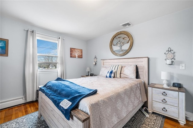 bedroom featuring hardwood / wood-style floors and a baseboard radiator