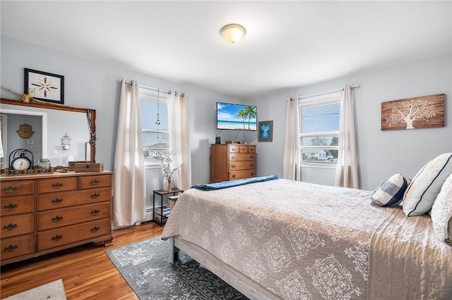 bedroom with multiple windows and light hardwood / wood-style flooring