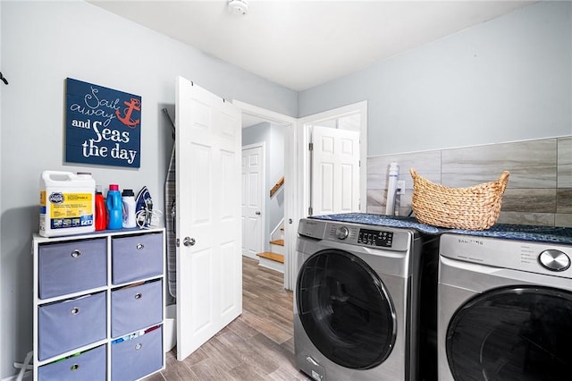 clothes washing area featuring washing machine and dryer and dark hardwood / wood-style flooring