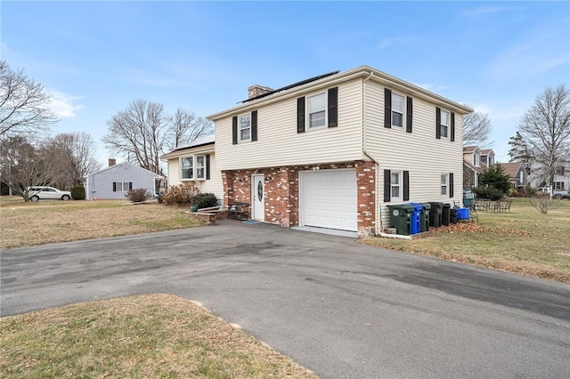 tri-level home featuring a garage and a front lawn