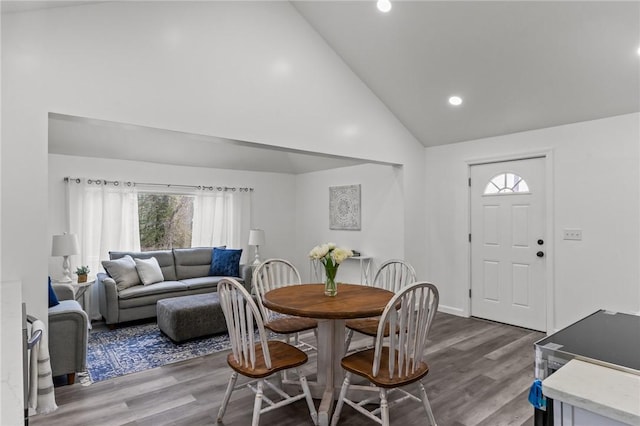 dining area featuring hardwood / wood-style floors and high vaulted ceiling