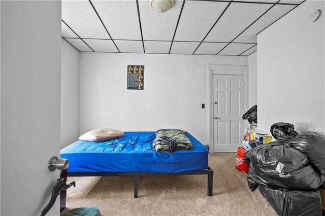 bedroom featuring carpet and a paneled ceiling