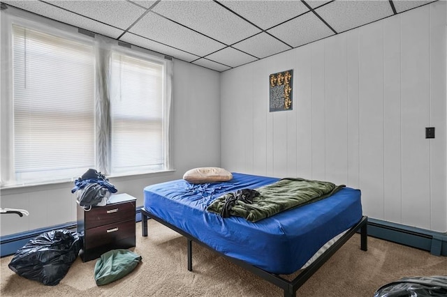 bedroom with a paneled ceiling, a baseboard radiator, and carpet flooring