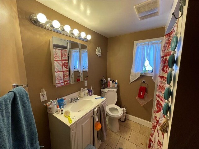 bathroom featuring tile patterned floors, vanity, and toilet