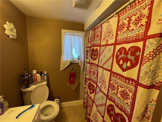 bathroom with curtained shower, toilet, and vanity