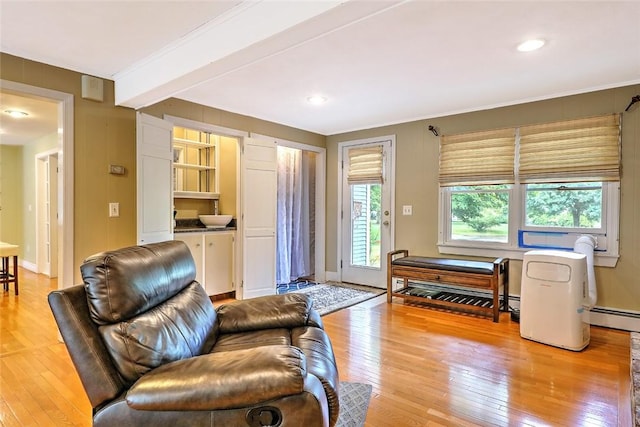 living room featuring beam ceiling, crown molding, a baseboard radiator, and light hardwood / wood-style flooring