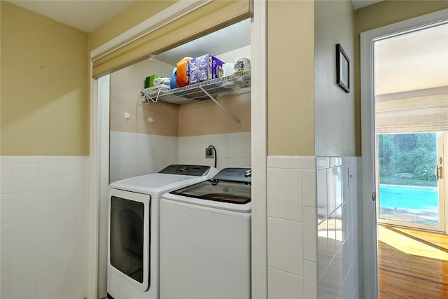 washroom featuring separate washer and dryer and tile walls