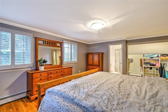 bedroom featuring hardwood / wood-style flooring, baseboard heating, multiple windows, and crown molding