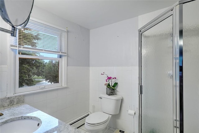 bathroom with baseboard heating, tile walls, a shower with door, and vanity