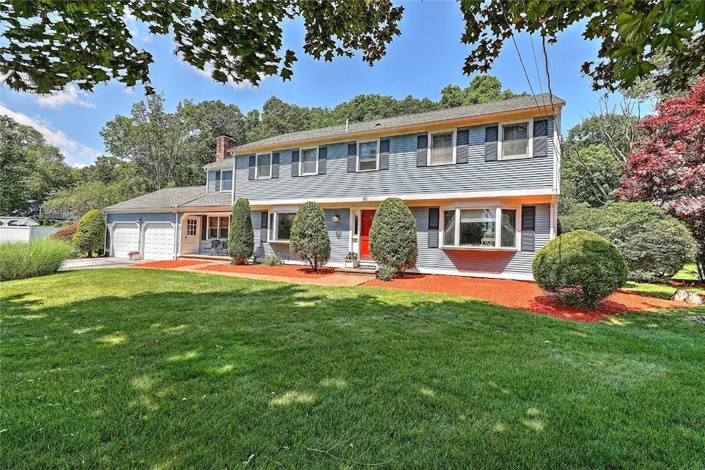 colonial-style house with a garage and a front yard