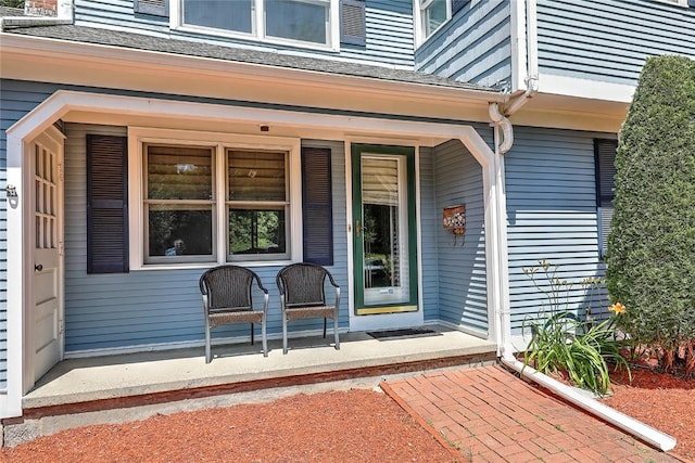 view of exterior entry featuring covered porch