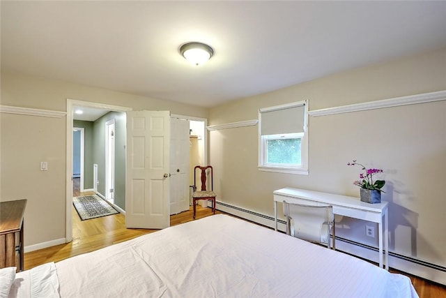 bedroom featuring hardwood / wood-style flooring and baseboard heating