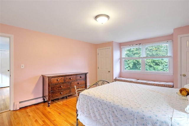 bedroom featuring baseboard heating and light hardwood / wood-style floors