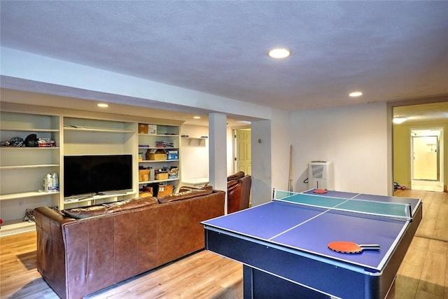 recreation room featuring built in shelves and wood-type flooring