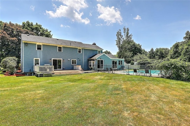 rear view of house featuring a pool side deck and a yard