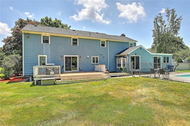 back of house featuring a wooden deck and a yard