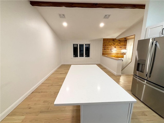 kitchen featuring a center island, lofted ceiling with beams, white cabinetry, light hardwood / wood-style flooring, and stainless steel fridge with ice dispenser