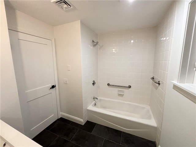 bathroom featuring tiled shower / bath combo and tile patterned floors