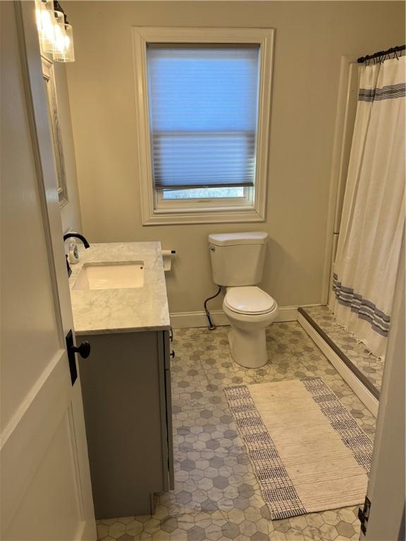 bathroom with toilet, vanity, and walk in shower