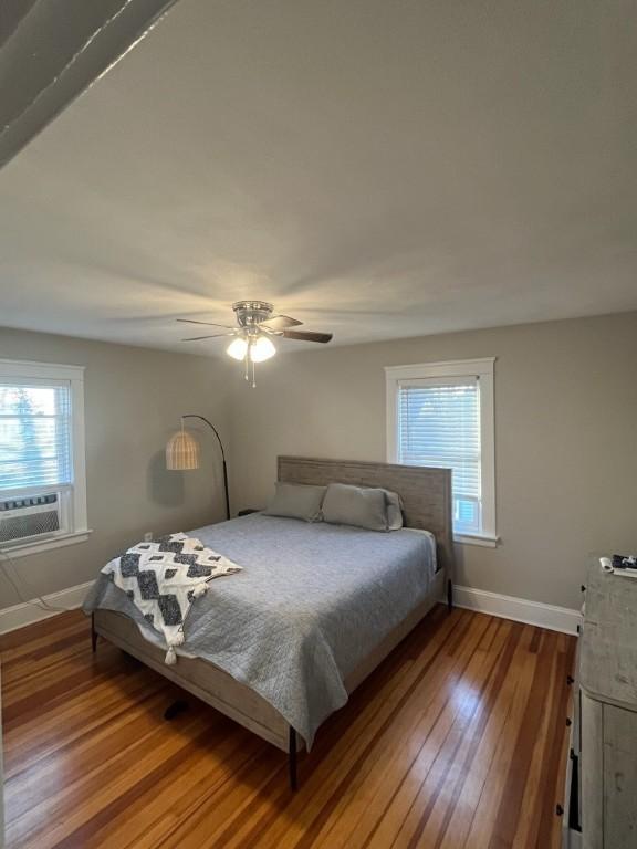 bedroom featuring ceiling fan, cooling unit, and hardwood / wood-style floors