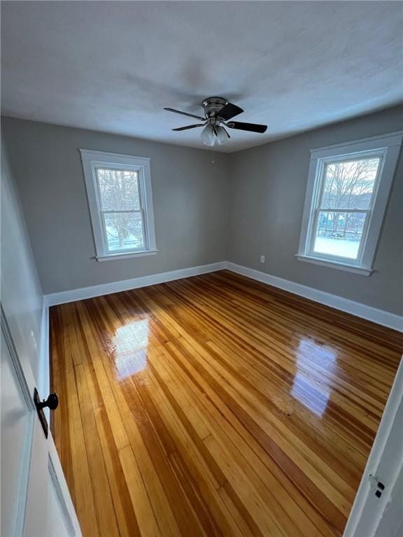 unfurnished room featuring ceiling fan, plenty of natural light, and hardwood / wood-style floors