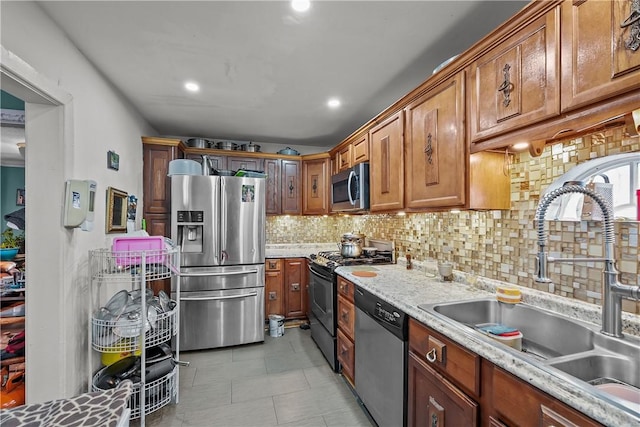 kitchen featuring decorative backsplash, appliances with stainless steel finishes, sink, and light stone counters