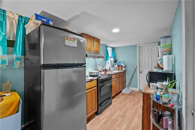 kitchen with stainless steel fridge, black range with electric cooktop, and light hardwood / wood-style floors