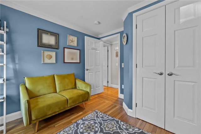 living area featuring wood-type flooring and crown molding